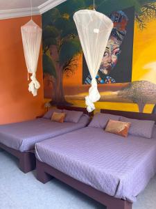 two beds in a room with a painting on the wall at Havre De Paix in Somone