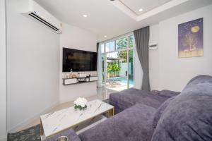 a living room with a couch and a table at Family villa with Private swimming pool Phuket in Ban Riang