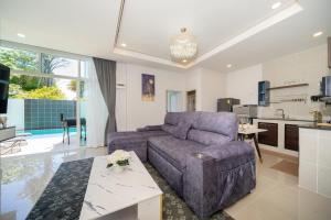 a living room with a couch and a kitchen at Family villa with Private swimming pool Phuket in Ban Riang