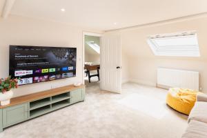 a living room with a large flat screen tv at Stunning Townhouse by the sea, Hot Tub sleeps 17 in Seaton