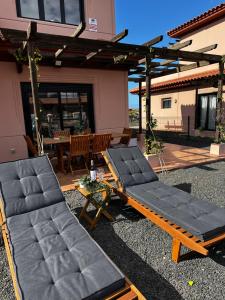 two lounge chairs and a hammock in a yard at Villa Macaronesia Lajares Fuerteventura Remote work in Majanicho