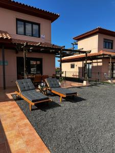 two chaise lounges in front of a house at Villa Macaronesia Lajares Fuerteventura Remote work in Majanicho