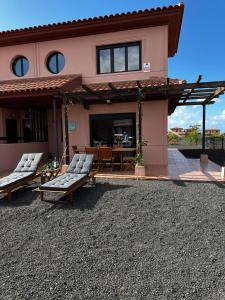 a house with two lounge chairs and a patio at Villa Macaronesia Lajares Fuerteventura Remote work in Majanicho +83 photos