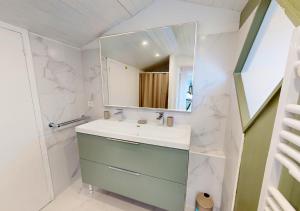 ein Badezimmer mit Waschbecken und Spiegel in der Unterkunft AIRIAL - Grand Appartement de standing en centre-ville in Soorts-Hossegor + 27 Fotos