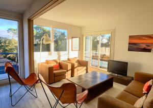 ein Wohnzimmer mit einer Couch und einem Tisch und Stühlen in der Unterkunft AIRIAL - Grand Appartement de standing en centre-ville in Soorts-Hossegor