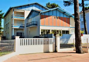 ein Haus mit einem weißen Zaun davor in der Unterkunft AIRIAL - Grand Appartement de standing en centre-ville in Soorts-Hossegor