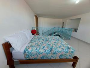 Dormitorio pequeño con cama con manta azul en Recanto Inglês, Prainha e Martim de Sá, en Caraguatatuba