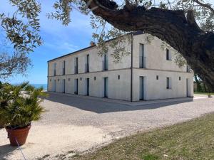 een extern uitzicht op een wit gebouw met ramen bij La Collina sul Mare in Porto SantʼElpidio