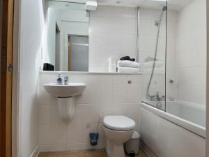 a bathroom with a toilet and a sink and a shower at 2 Bed 2 bath with Private Parking in Edinburgh