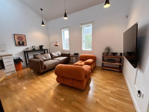 a living room with two couches and a flat screen tv at 2 Bed 2 bath with Private Parking in Edinburgh