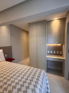 a bedroom with a bed and a cabinet at Cobertura com piscina privativa - Apart hotel in Salvador +11 photos