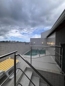 a balcony with a swimming pool on top of a building at Cobertura com piscina privativa - Apart hotel in Salvador