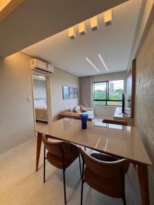 a room with a table and chairs and a couch at Cobertura com piscina privativa - Apart hotel in Salvador