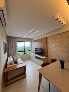 a living room with a couch and a television at Cobertura com piscina privativa - Apart hotel in Salvador
