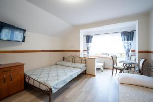 a bedroom with a bed and a table and chairs at Chata Jana in Łeba