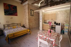 a bedroom with a bed and a table and a kitchen at Luisa's in Cagliari