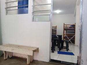 a room with a table and chairs and a wall at Suítes Cristall in São Sebastião
