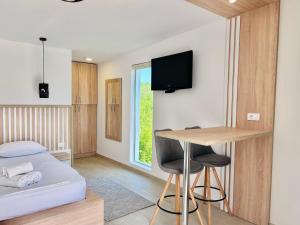 a small room with a bed and a table and a desk at Tiny House with Hot Tub & View in Ulcinj