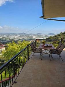 a patio with a table and chairs on a balcony at Mountain paradise in Elevtheraí