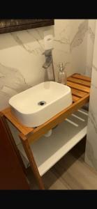 - un lavabo blanc sur une étagère en bois dans la salle de bains dans l'établissement Apartamento de Frente para Lagoa - Ap 103, à Laguna 12 autres photos