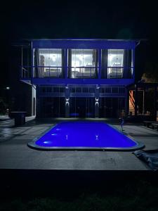 - une grande piscine bleue devant un bâtiment la nuit dans l'établissement Apartamento de Frente para Lagoa - Ap 103, à Laguna