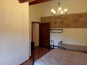 a bedroom with two beds and a chandelier at Podere Santa Benedetta camera in Ribolla