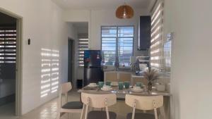 a kitchen with a table and chairs and a kitchen withwindows at BM IconCity Landed Home by Wemestay - Near AutoCity, Juru, Penang Bridge in Bukit Mertajam