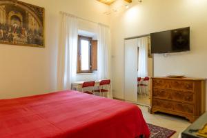 a bedroom with a bed and a dresser with a flat screen tv at kis inn affitacamere guesthouse in Rome
