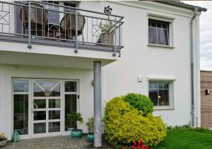 a white house with a balcony and a patio at 30 qm Fewo ländliche Lage Nossen in Nossen