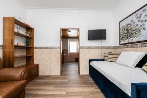 a bedroom with a bed and a couch and a television at Casa da Muralha in Beja