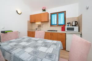 kuchnia ze stołem i kuchenką mikrofalową w obiekcie Cozy Apartment Abazi w Puli