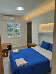 Un dormitorio con una cama azul con dos toallas encima. en Villa Berria Alfabia, en Palma de Mallorca 63 fotos más