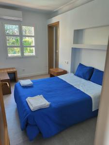 Un dormitorio con una cama azul con dos toallas encima. en Villa Berria Alfabia, en Palma de Mallorca