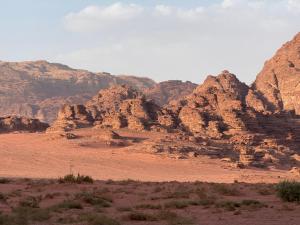 a view of a desert with mountains in the background at Wadi Rum Thamer in Wadi Rum