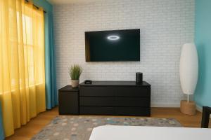 a living room with a tv on a white brick wall at Blue style Room in New York