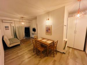 a living room with a wooden table and chairs at Apollo Peraia Apartment in Perea