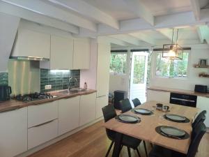 a kitchen with a wooden table with chairs and a dining room at Chalet Het Bosnestje Durbuy in Durbuy