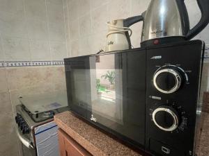 a microwave with a tea kettle on top of it at Adam Madinaty hotel in Madinaty