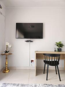 布拉瓦约8 On Dianne Guesthouse的墙上有电视的房间里一张黑椅子