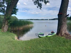dos kayaks sentados en la orilla de un lago en Domek w Bogaczewie nad jeziorem Narie, en Bogaczewo 20 fotos más