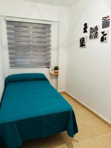a bedroom with a blue bed and a window at Esparta Home ! in Córdoba