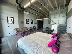 プラハにあるLuxe studio with pool, sauna, jacuzzi, gym, balconyのピンクの枕が付いた大きなベッドのある寝室 +18枚の写真