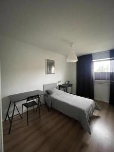 a bedroom with a bed and a table and a window at Tallinn Street Apartment in Kuressaare