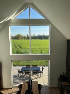 Una habitación con una mesa y una ventana grande. en Les Villas du Ried, en Daubensand