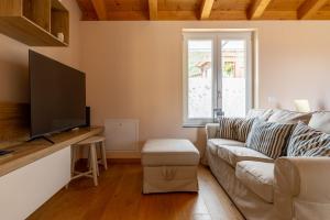 a living room with a couch and a flat screen tv at Apartment Boutique - Menaggio in Menaggio
