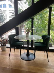 a glass table with two chairs and a table at Comfortable apartment in Reforma, downtown CDMX in Mexico City