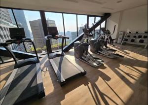 a gym with several tread machines in a room with a window at Comfortable apartment in Reforma, downtown CDMX in Mexico City