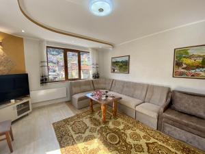 a living room with a couch and a table at Апартамент и Студио Перелик in Chepelare