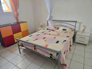 a bedroom with a bed with a comforter on it at Appartement idéal, à deux pas de la mer, de la gare maritime et du centre-ville in Saint-François