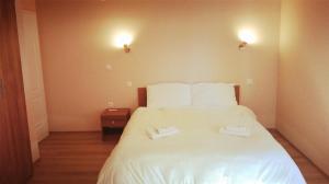 a bedroom with a white bed with two towels on it at Pansion Eden in Međugorje